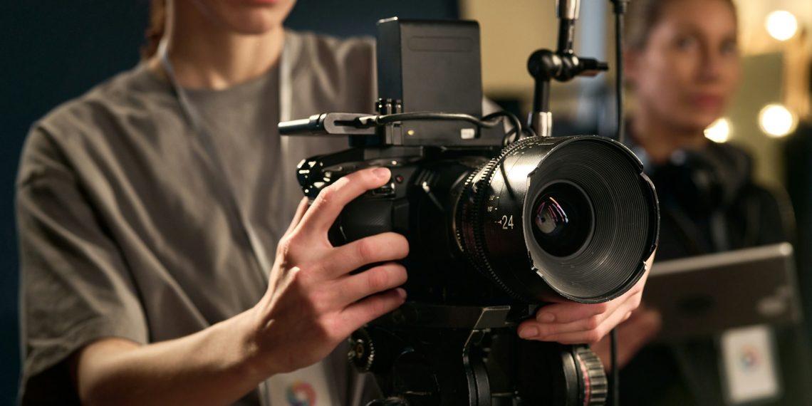 Female Hands Holding Professional Video Camera